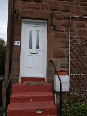 a white door on the side of a brick house at Smriti's in Dumfries