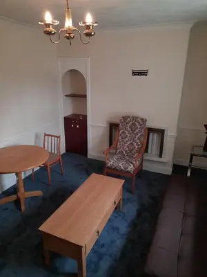 a living room with a table and a chair at Smriti's in Dumfries