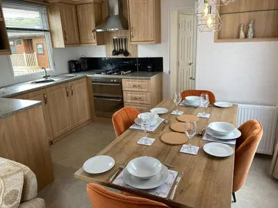 a kitchen with a wooden table with plates and glasses on it at Rosie in Whithorn
