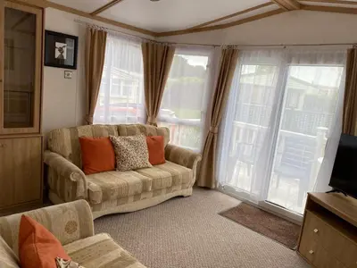 a living room with a couch and a large window at Rosie in Whithorn