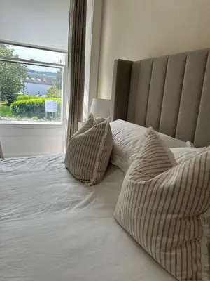 a bed with two pillows on it with a window at Luxury High Street Apartment in Moffat