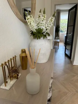 a vase filled with flowers sitting on top of a table at Luxury High Street Apartment in Moffat