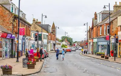 a city street with people walking down the street at DeiRa Hotel & Apartments in Prestwick