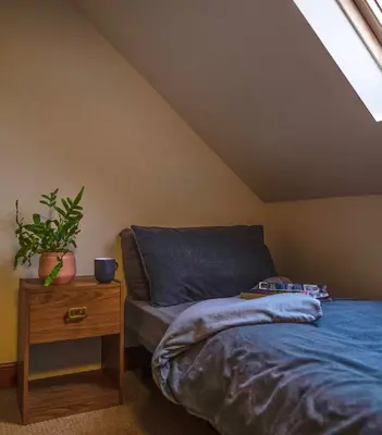 a bedroom with a bed and a table with a plant at No5 The Smiddy in Wigtown