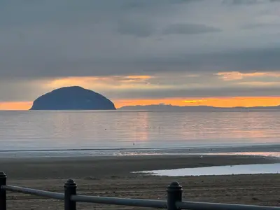 a view of a beach with a rock in the water at Peel House Bed and Breakfast in Girvan
