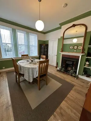 a dining room with a table and a fireplace at Peel House Bed and Breakfast in Girvan