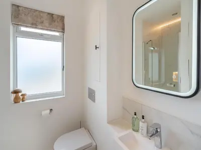 a bathroom with a white toilet and a mirror at Berkeley in Kippford