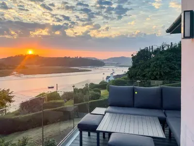a balcony with a couch and a view of a river at Berkeley in Kippford