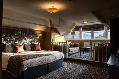 a bedroom with a bed and a couch in a room at Keswick Country House Hotel in Keswick