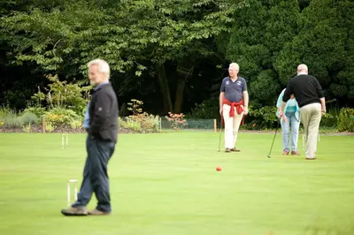 a group of people playing golf on a field at Keswick Country House Hotel in Keswick