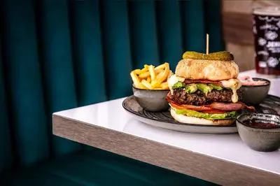 a plate with a hamburger and french fries on a table at Skiddaw Hotel in Keswick