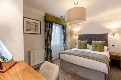 a hotel room with a large bed and a television at Skiddaw Hotel in Keswick