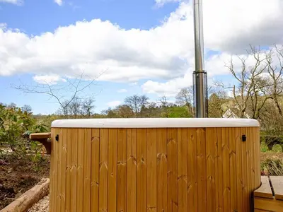 a wooden fence with a pole on top of it at Lintmill Lodges - Bluebell Shepherds Hut in Sorn