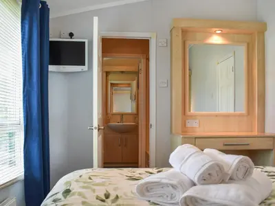 a room with a bed and a sink and a mirror at Meadows Lodge - Uk46825 in Plumbland