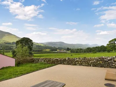 a stone retaining wall and a patio with a stone fence at Uk46833 - Low Hollas Farmhouse in Threlkeld