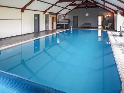 a large swimming pool with blue water at Stackgarth in Gilcrux