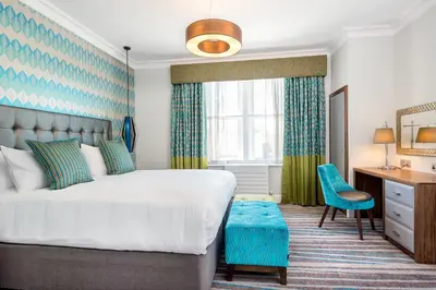 a bedroom with a bed and a desk and a chair at Inn on the Square in Keswick
