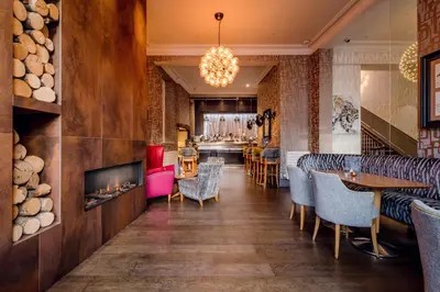 a restaurant with a fireplace and tables and chairs at Inn on the Square in Keswick