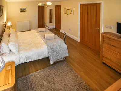 a bedroom with a large bed and a television at The Bothy in Ivegill