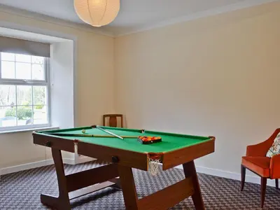 a room with a pool table and a window at Park Cottage in Gatehouse of Fleet