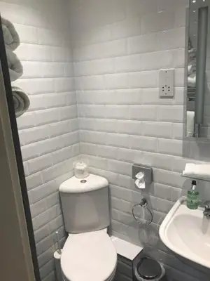 a white bathroom with a toilet and a sink at Daviot Guest House in Ayr