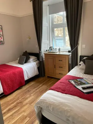 a bedroom with two beds and a window at Daviot Guest House in Ayr