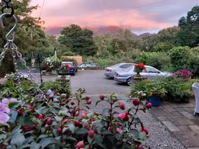 a parking lot with parked cars and flowers at Lakeside Country Guest House in Bassenthwaite Lake