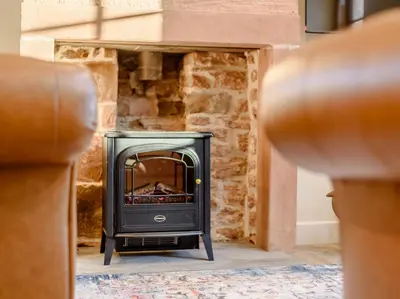 a stove in front of a stone fireplace at 2 Bed in Dalston 93820 in Dalston