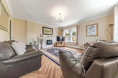 a living room with two leather couches and a tv at Stickle Tarn in Keswick