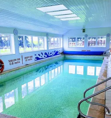 an indoor swimming pool with a pool at Lochview Retreat Caravan in Balminnoch
