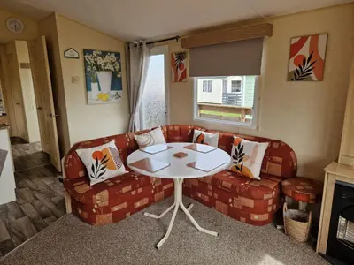 a living room with a couch and a table at Lochview Retreat Caravan in Balminnoch