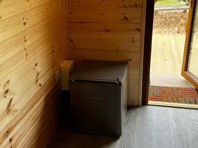 a small refrigerator in a room with a window at Howbeck Lodge in Hesket Newmarket