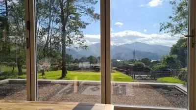 a window looking out at a view of a park at Swallows Lodge in Keswick