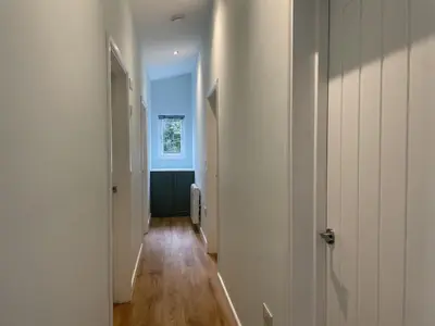 a hallway with white walls and wooden floors at Swallows Lodge in Keswick