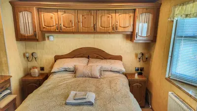 a bedroom with a bed with two towels on it at Turnberry Holiday Park in Turnberry