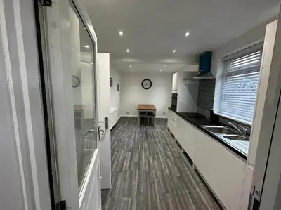 a kitchen with a sink and a clock on the wall at Large 3 bed property in Whitehaven