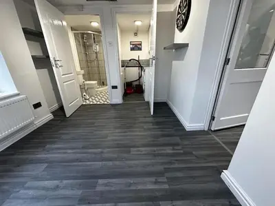a hallway with a bathroom with a toilet and a door at Large 3 bed property in Whitehaven