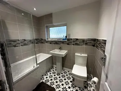 a bathroom with a toilet and a sink and a tub at Large 3 bed property in Whitehaven