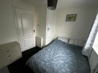 a bedroom with a bed and a white door at Large 3 bed property in Whitehaven