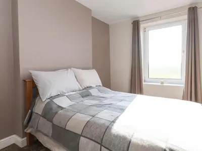 a bedroom with a bed and a window at 2 South Street in Wigton