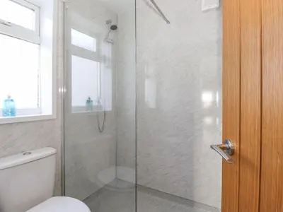 a bathroom with a shower with a toilet and a glass door at 2 South Street in Wigton