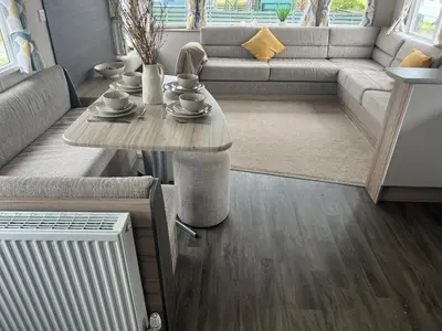 a living room with a table and a couch at Robinson retreats beautiful caravan with sea views pet friendly in Mainsriddle