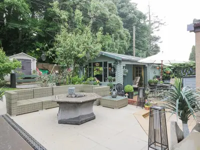 a garden with a bench and a house at Scotia At The Pow in Annan