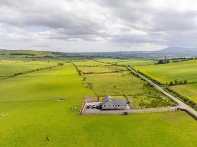 an aerial view of an old house in a field at Berryrigg Cottage in Dumfries
