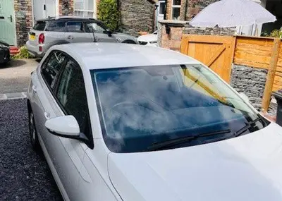a white car parked on the side of a street at Anley Cottage with garden and private parking in Keswick in Keswick