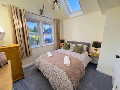 a bedroom with a large bed and a window at Anley Cottage with garden and private parking in Keswick in Keswick