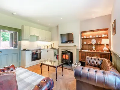 a living room with a couch and a fireplace at The Coach House in Longtown