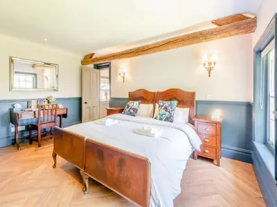 a bedroom with a large bed and a table at The Coach House in Longtown