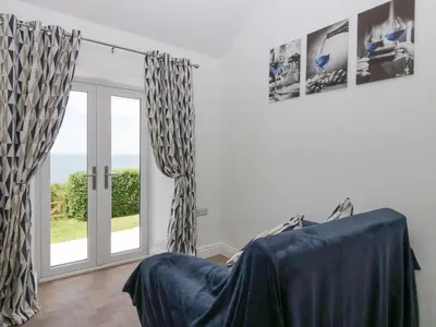 a room with a sliding glass door and a window at Victroneen Cottage in Whitehaven