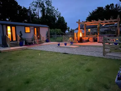 a backyard with a tiny house and a patio at Millburn Mini Farm in Kilwinning